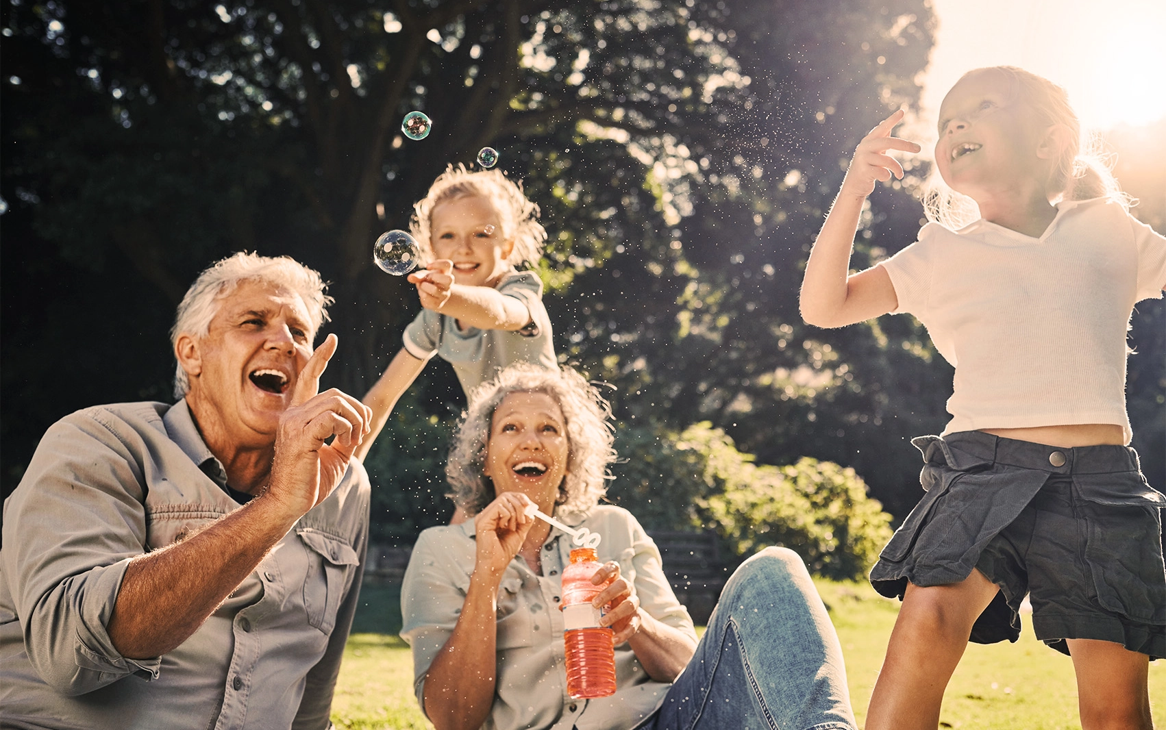 Grandparents blowing bubbles with grandchilden